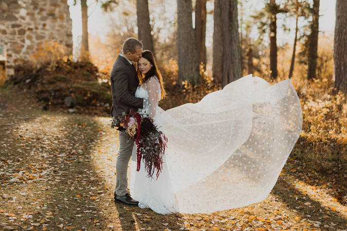Bröllopsklänning som blåser i vinden i solnedgången