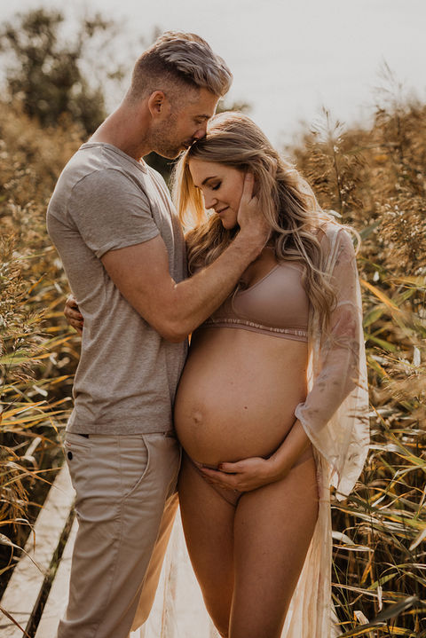 En gravid kvinna som blir kramad av sin man