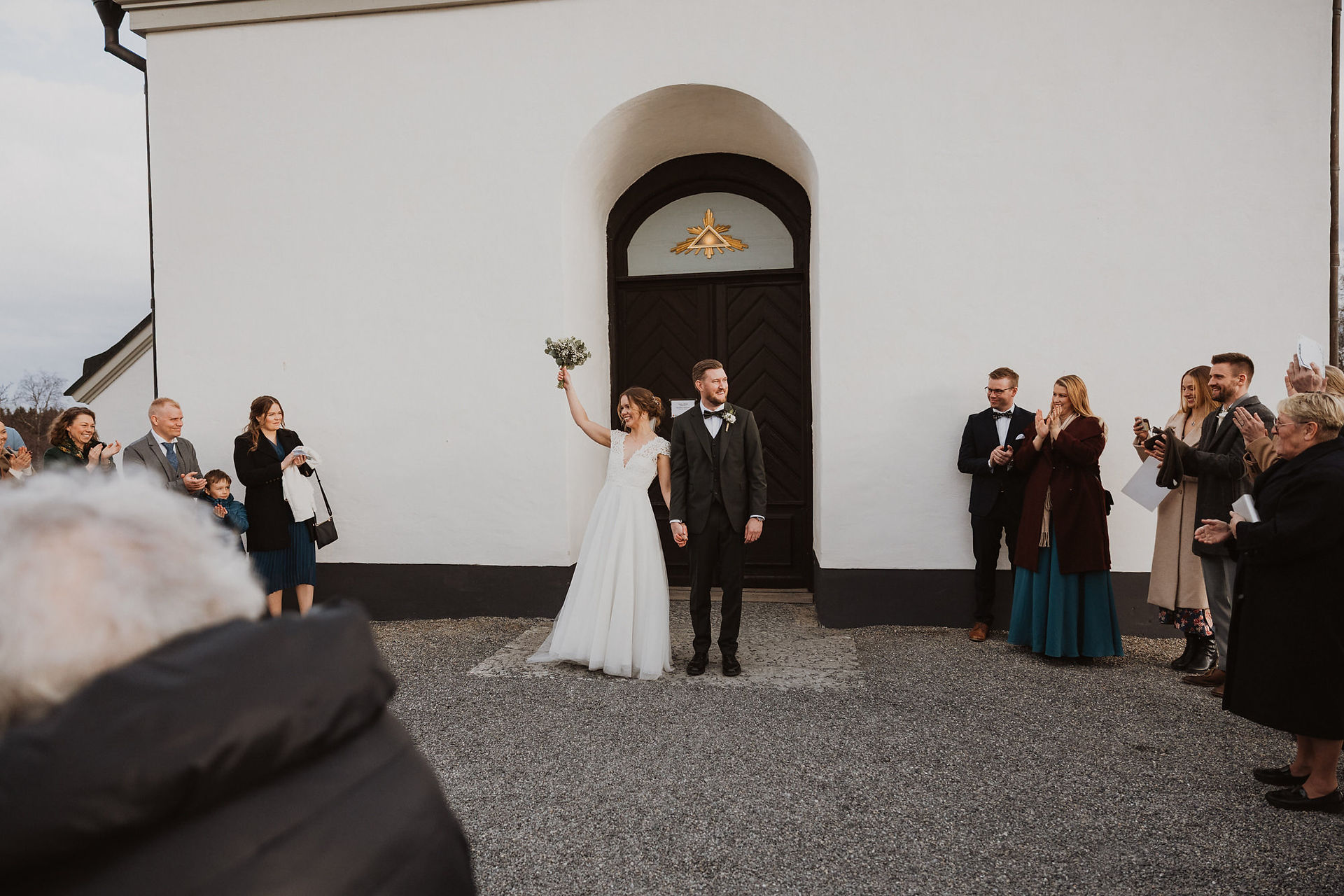 Brudpar möts av gästerna utanför kyrkan