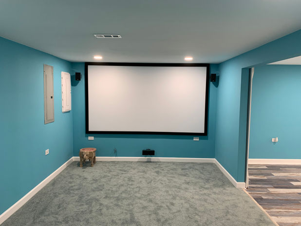 Installed vinyl plank floor tiles, recessed ceiling lights, barn doors in theater room.