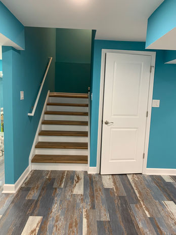 Installed vinyl plank floor tiles, recessed ceiling lights, barn doors in theater room.