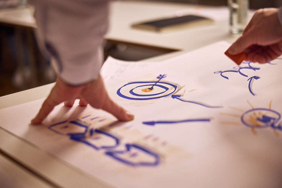 Mehrere Personen im Business-Kontext entwickeln gemeinsam eine Vertriebsstrategie – symbolisiert fokussiertes Handeln und strategische Ausrichtung in wirtschaftlich herausfordernden Zeiten.