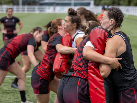 London Broncos Women prepare for a game by hitting tackle bags in their warm up