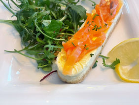cheesecake fromage frais saumon fumé dans une assiette blanche avec de la roquette et une rondelle de citron