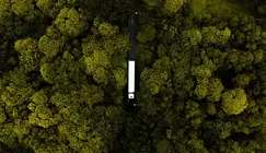 Aus der Vogelperspektive: Ein E-Lkw fährt durch einen grünen Wald