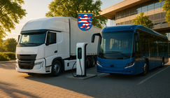 E-Lkw und ein E-Bus laden im abendlichen Sonnenschein in Hessen an einer Ladesäule