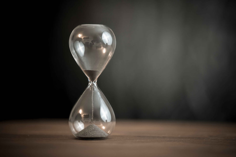 Minimalist hourglass on a wooden surface, symbolizing time management, urgency, and the importance of disciplined routines.