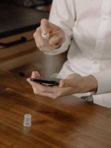 person in white dress shirt holding black smartphone