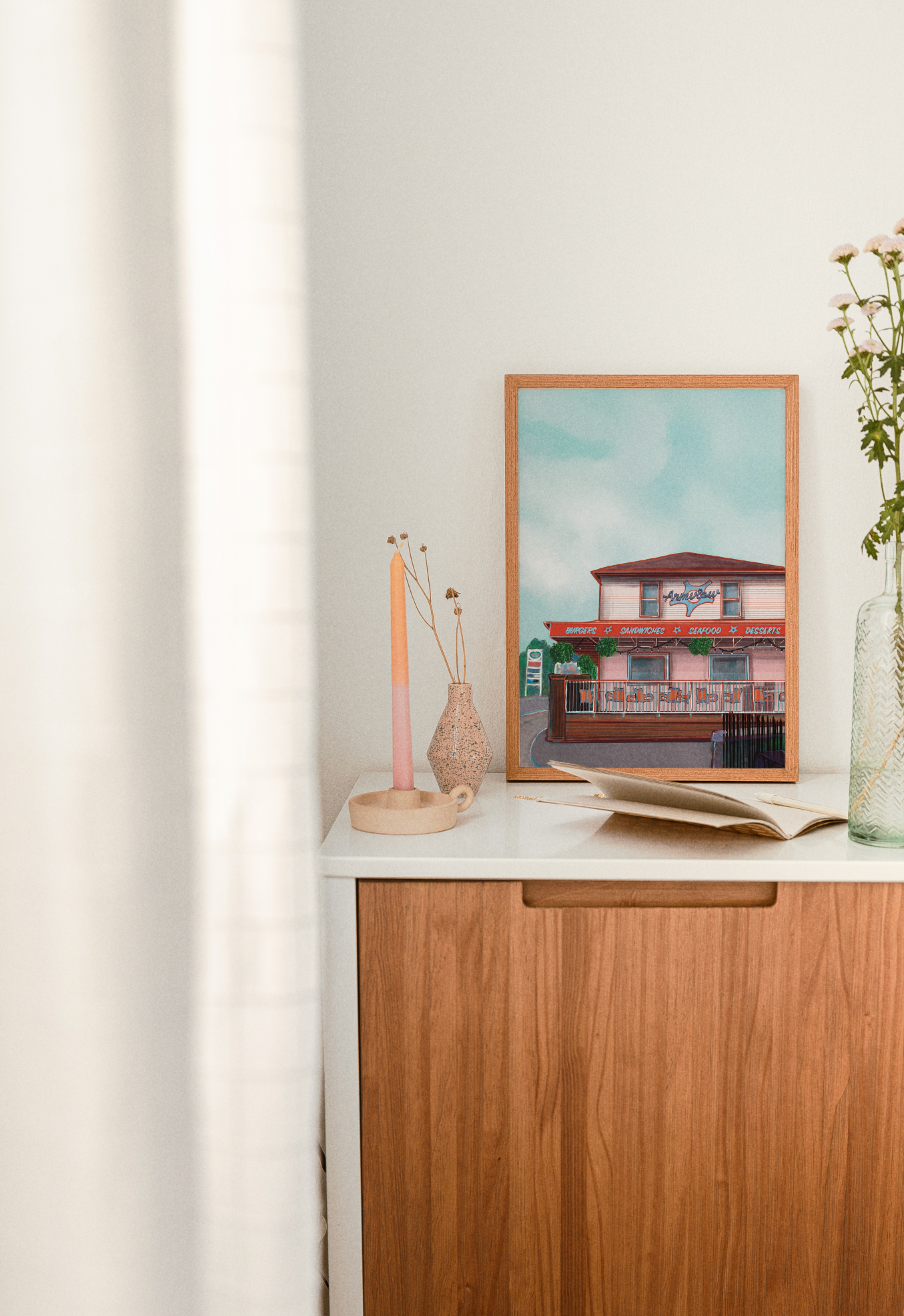 Thumbnail: Outside The Armview Print framed in an oak picture frame sitting on a dresser next to decor and books.