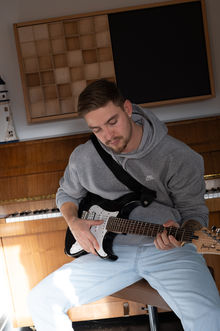 Ein Produzent spielt die Gitarre.