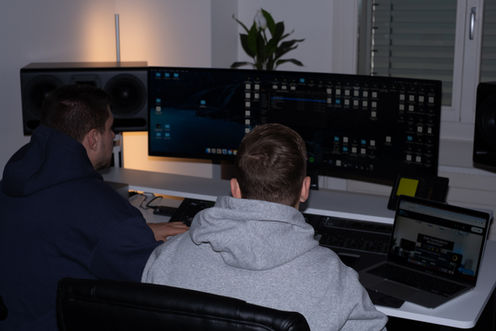 Atmosphärische Bildaufnahme im Tonstudio mit zwei Produzenten.