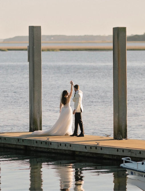 Bride and groom standing on the Greyfield Inn dock overlooking the marsh at sunset on Cumberland Island.