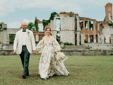 Bride and groom walking hand-in-hand in front of the Dungeness Ruins on Cumberland Island after their elopement ceremony.
