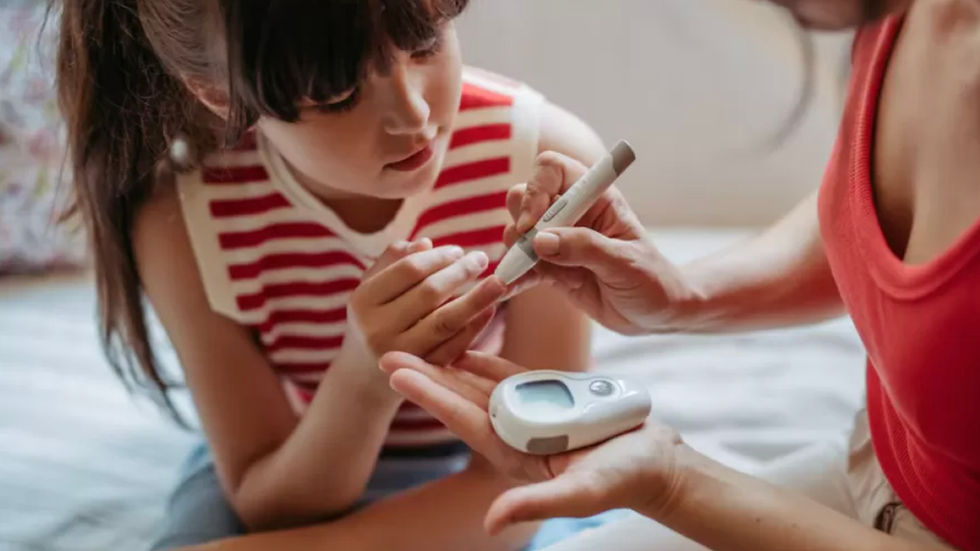 Una madre hace test glucémico a su hija