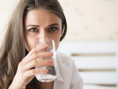 Mujer sedienta bebiendo agua con un vaso