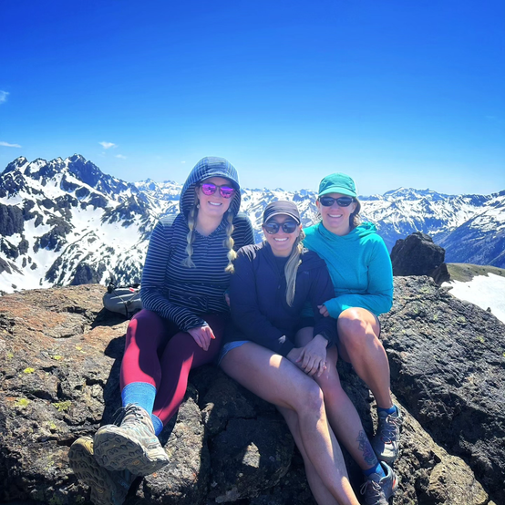 Darcy, Amy, and Shari at the top of Buckhorn Mountain with the Olympic Mountain Range in the background.