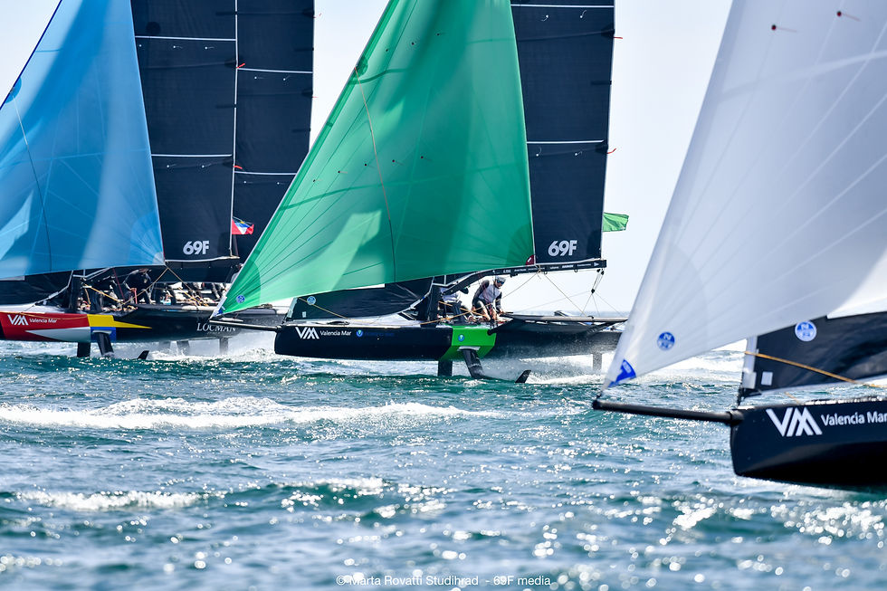 Oceana Vivo racing with their spinnaker up between two other boats.