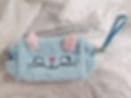 Light blue fluffy pouch with a cat face and ears.