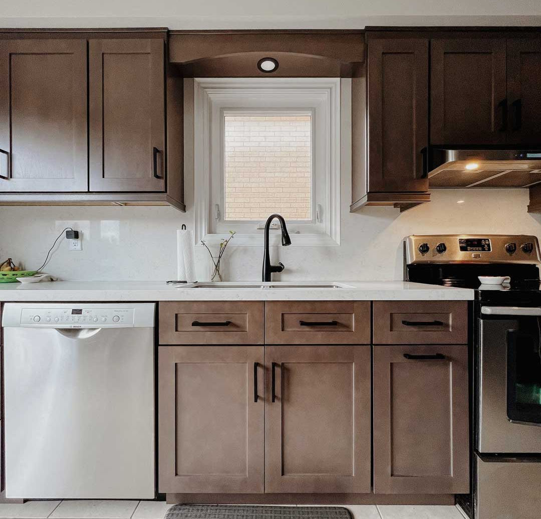 Contemporary kitchen remodel featuring bespoke cabinets and elegant finishes, graphite shaker sink, and dishwasher