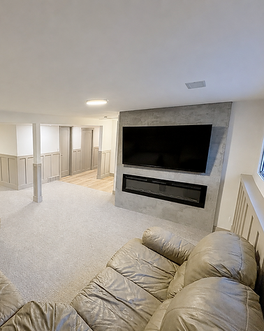 Modern basement fireplace update featuring electric fireplace conversion and concrete-look surround.