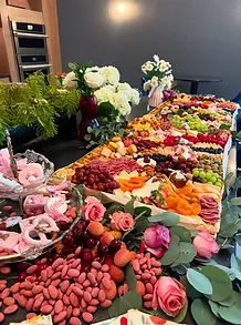 Beautiful grazing table with fresh fruit, artisan charcuterie, edible flowers and elegant event styling.