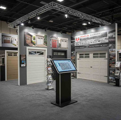 Large trade show booth installation with wall-to-wall gray event carpet flooring.