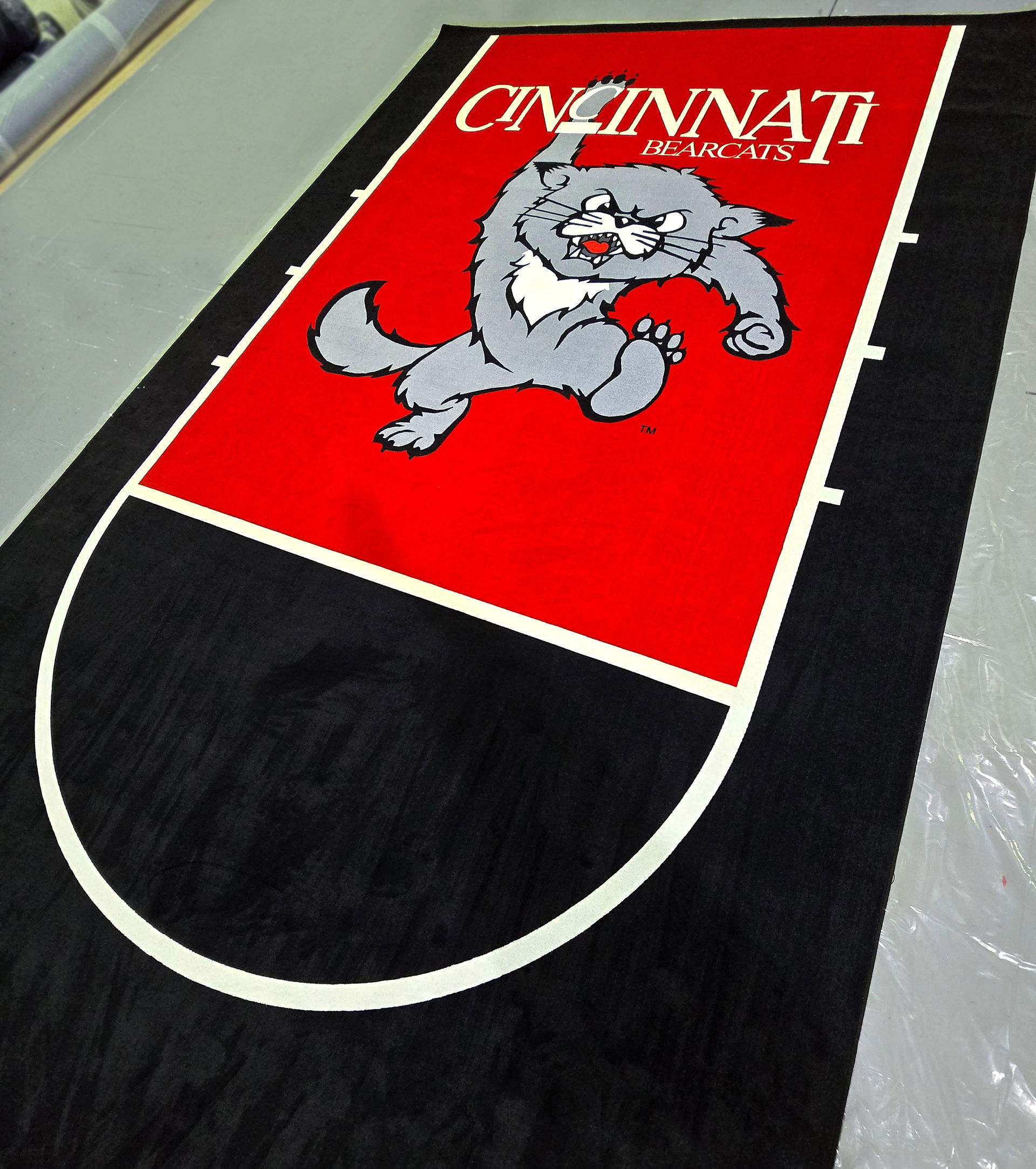 Black, red, and white custom printed carpet featuring a university mascot graphic and bold branded design