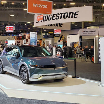 Custom trade show vinyl flooring in an automotive booth display with a vehicle at a convention center.