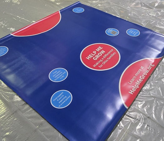 Custom reverse printed vinyl flooring with blue branded graphic design and promotional messaging for long-term retail or exhibit floor installation.
