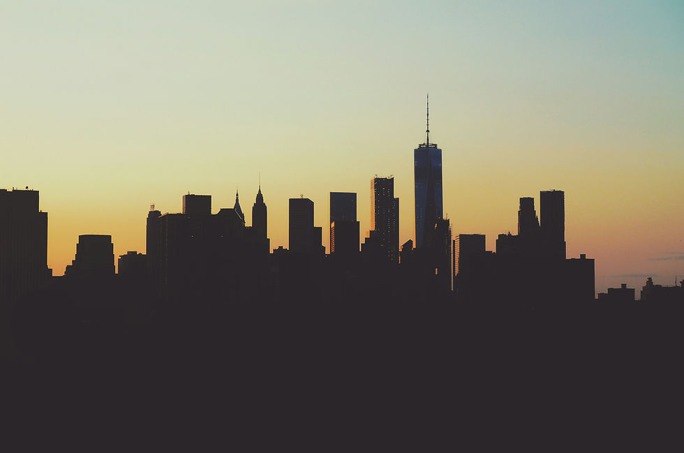 Sunset silhouette of a city skyline with prominent skyscrapers.