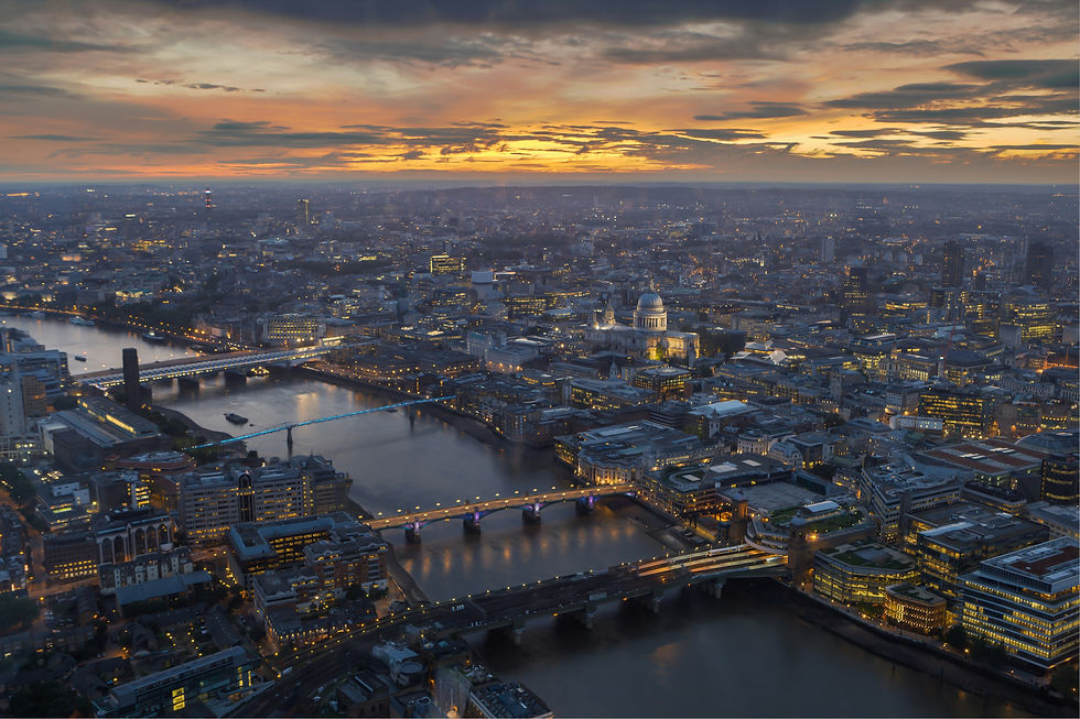 Aerial view of London at sunset, showcasing the Thames River, bridges, and cityscape with St. Paul's Cathedral.