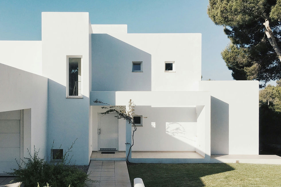 Modern white house with a minimalist design and a tree