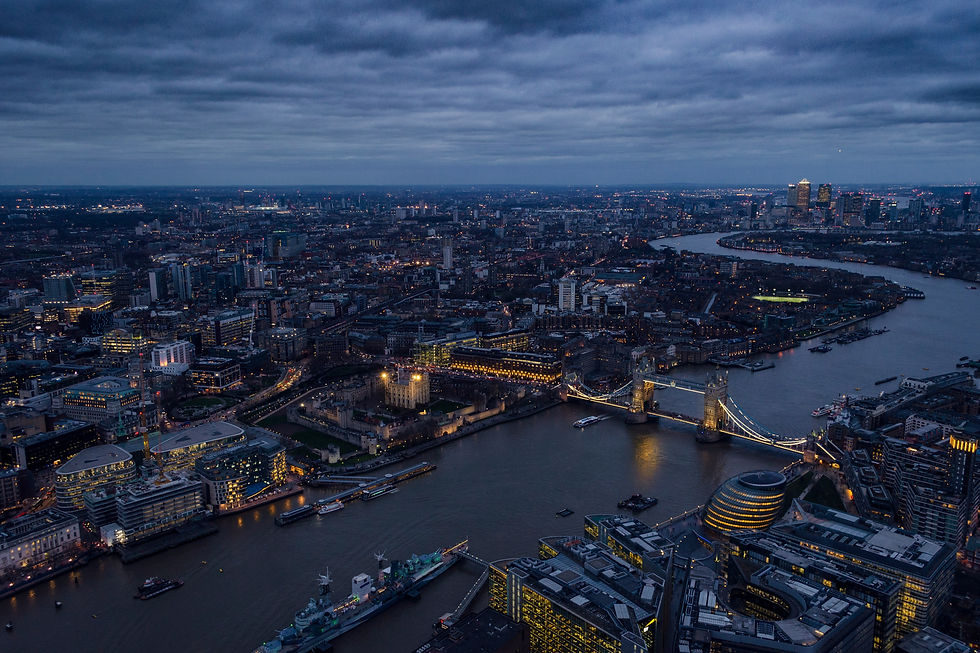An aerial view of London at dusk with the Thames River and Tower Bridge visible