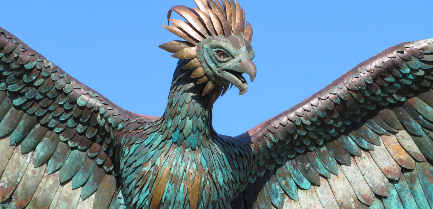 Close-up of a bronze sculpture of a phoenix with outstretched wings