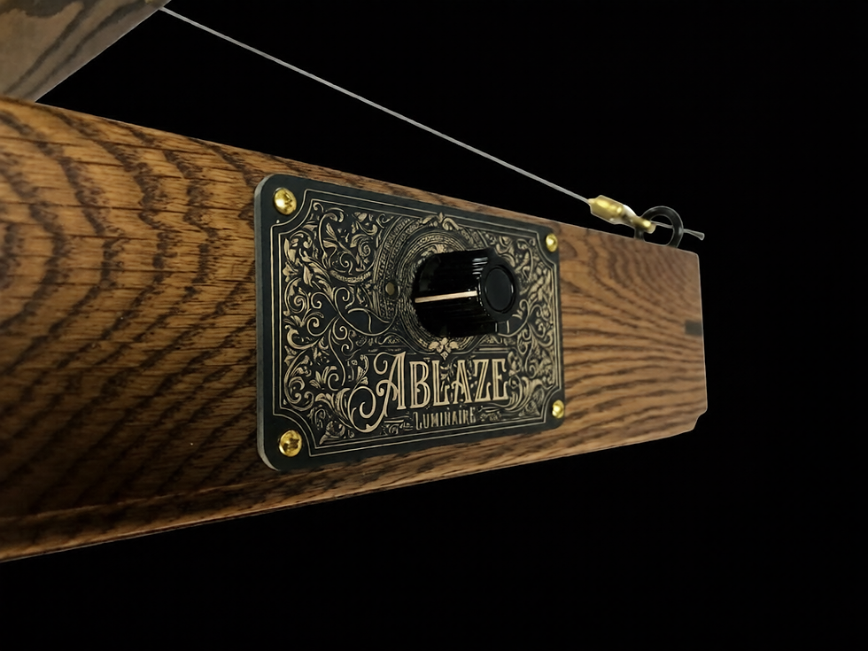 Thumbnail: Close up of decorative gold and brass Ablaze Luminaire plaque, showing oak woodgrain detail, brass hardware, aircraft cable