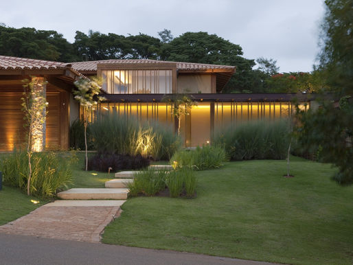 Casa de campo mistura materiais naturais e se integra à mata