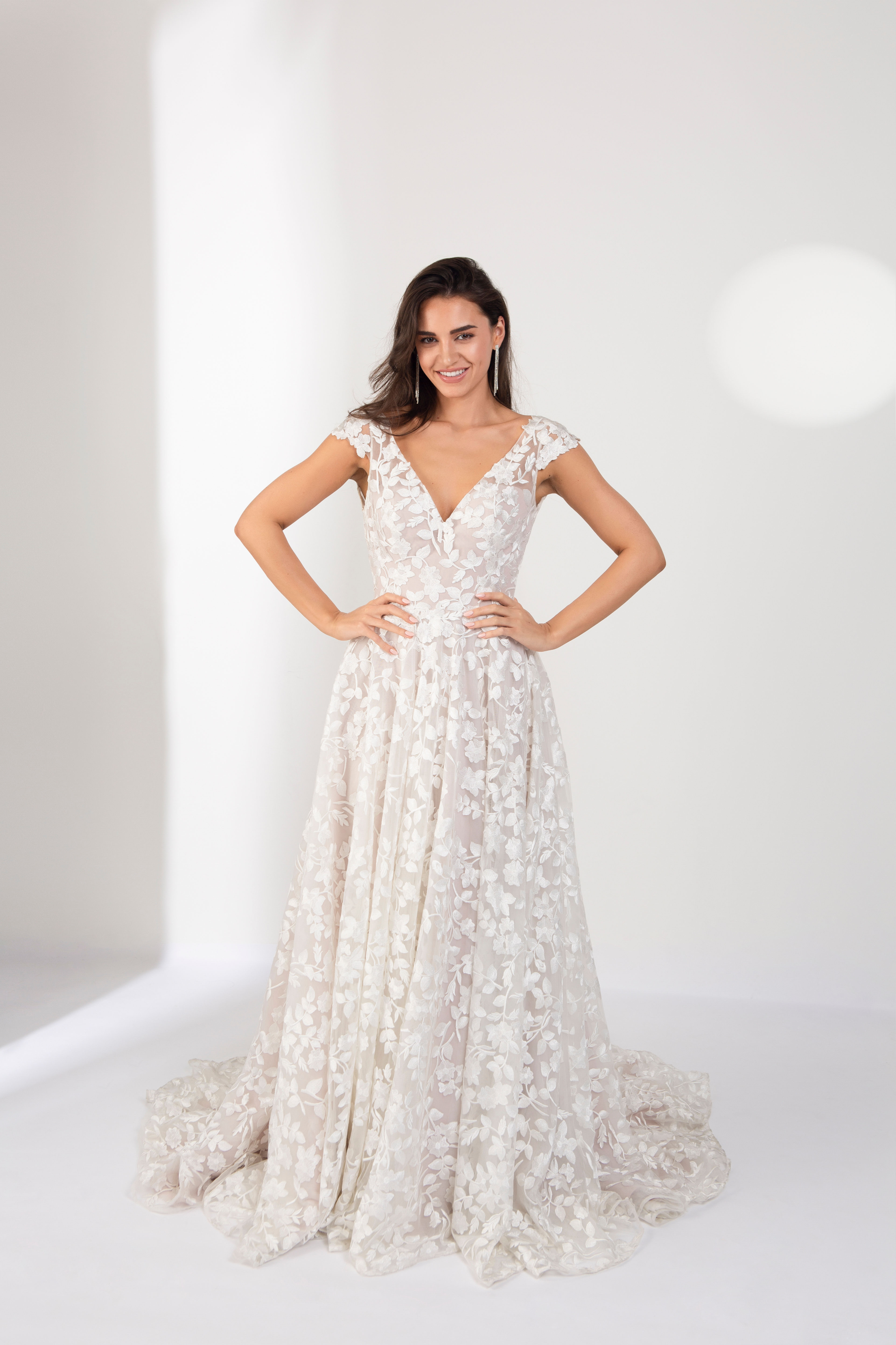 Lace and tulle ivory and nude bridal dress with of-shoulder straps and lace applique all over the bodice for beach wedding