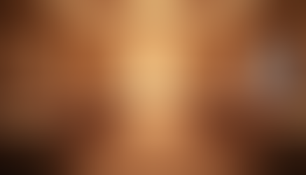 A wedding venue ballroom set up for an event with soft lighting and decorations