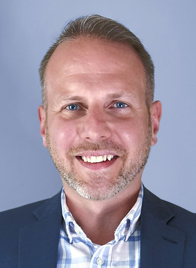 Headshot of smiling man in suit