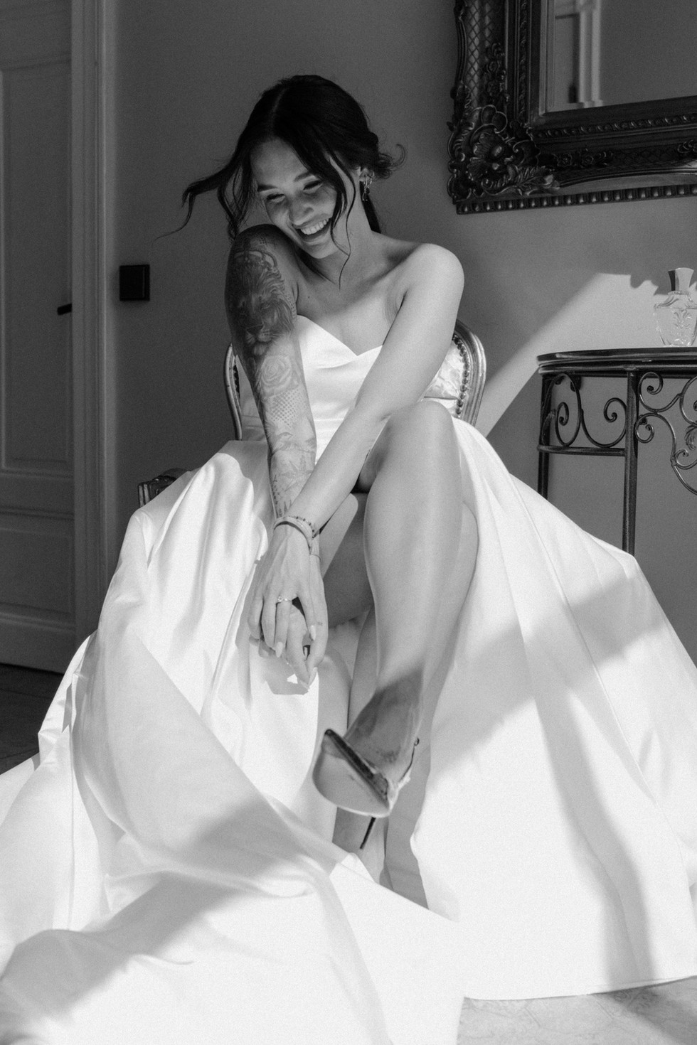 black and white shot of the bride in her dress sitting on the chair enjoying her moment before the wedding