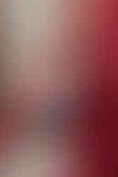 Editorial-style pose of couple in earthy red tones against historic stone textures