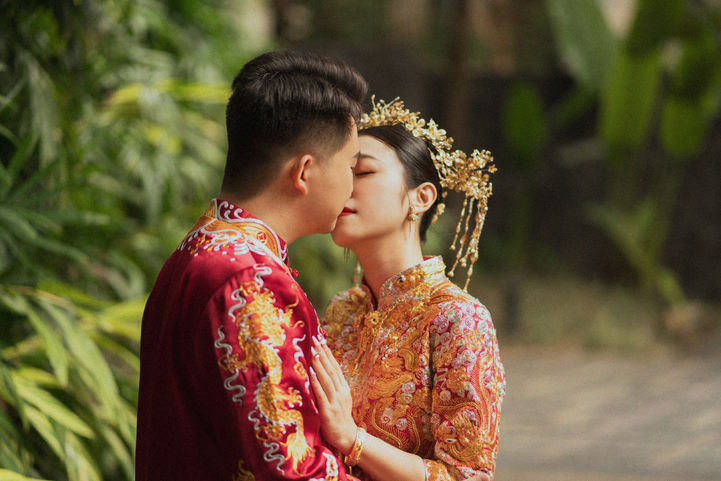 A bride and groom in traditional Chinese wedding attire having their photoshoot