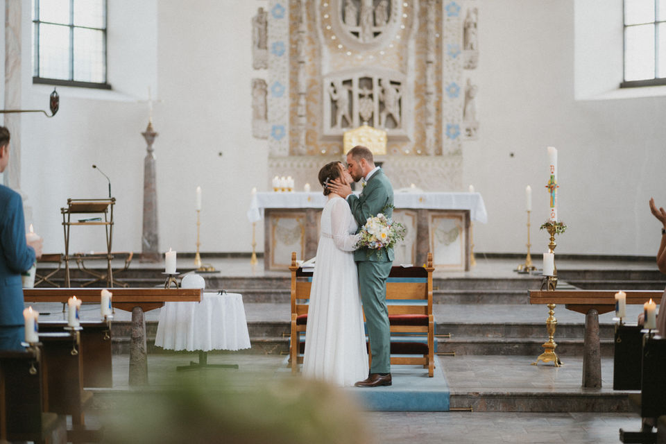 A Swedish and German couple sharing their first kiss during their intercultural wedding ceremony in Bonn, Germany.