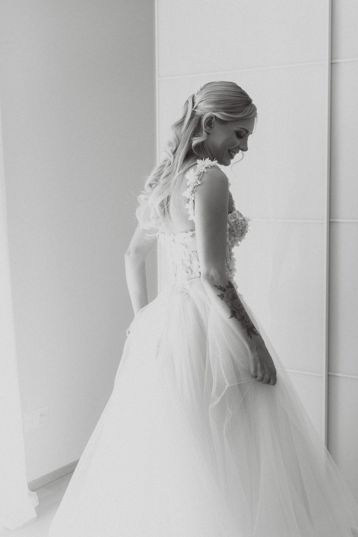 the bride putting on her wedding dress with her mom