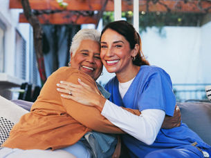 Caregiver and senior woman hugging