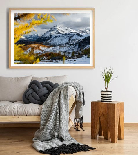 Thumbnail: Mountain landscape framed art above sofa, wooden table, and plant pot. Smittys Smicko Phot
