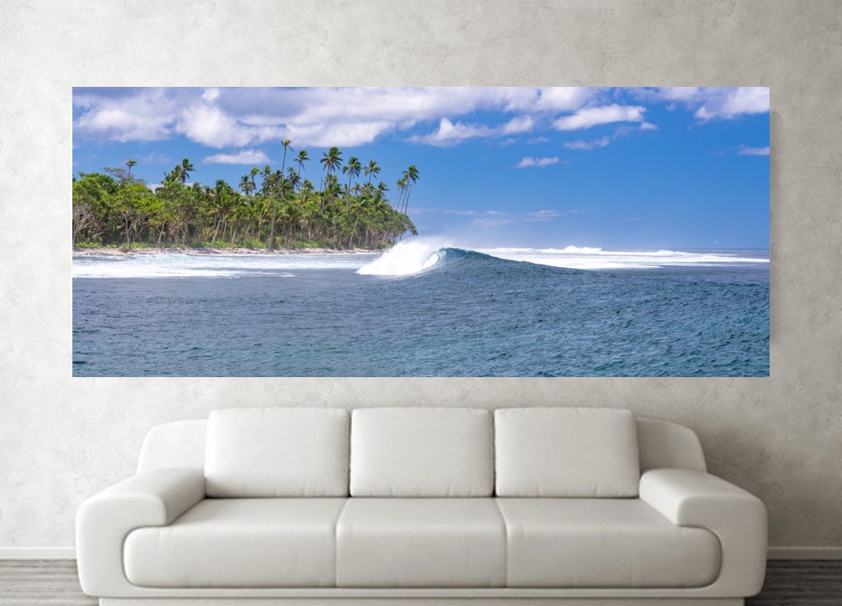 Ocean wave crashes near the shore, with palms trees visible in background.