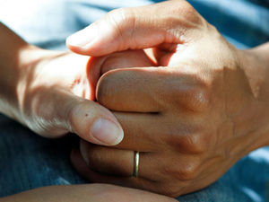 elderly woman holding nurse's hand
