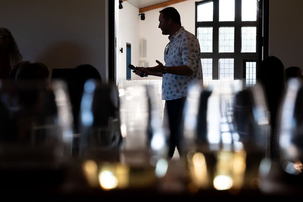 Male speaker in silhouette with the venue softly lit behind him
