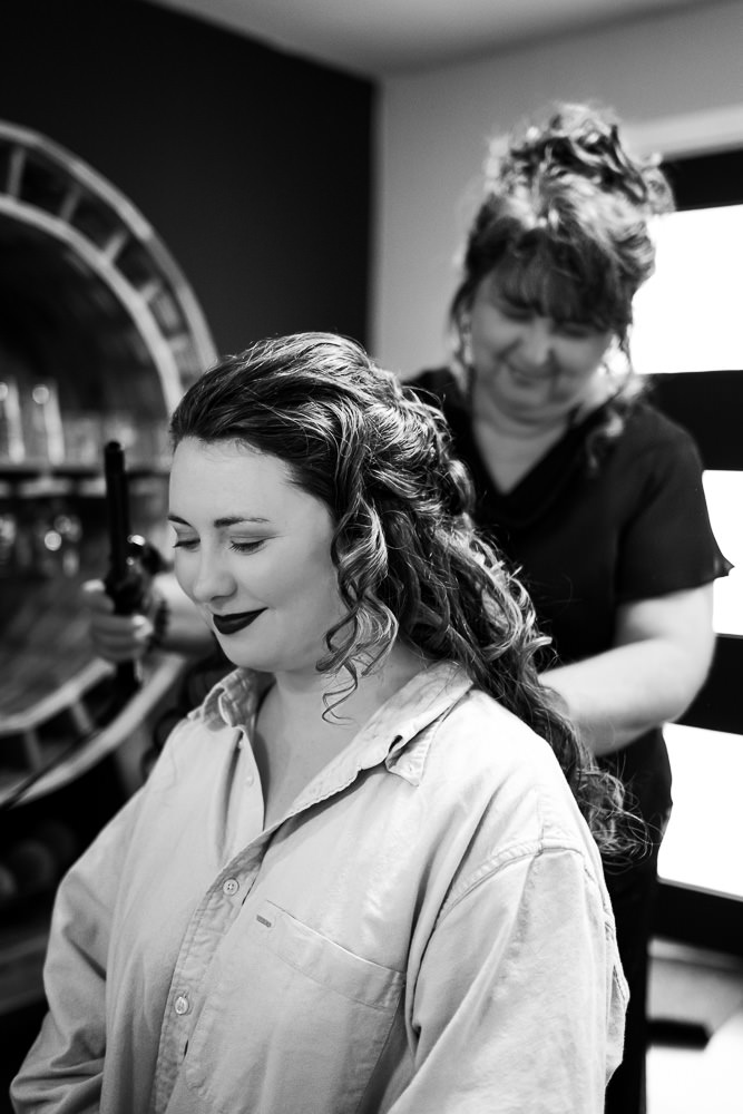 Black and white photo: A tender moment as the bride's mother gently adjusts Tamieka's hair before the wedding.